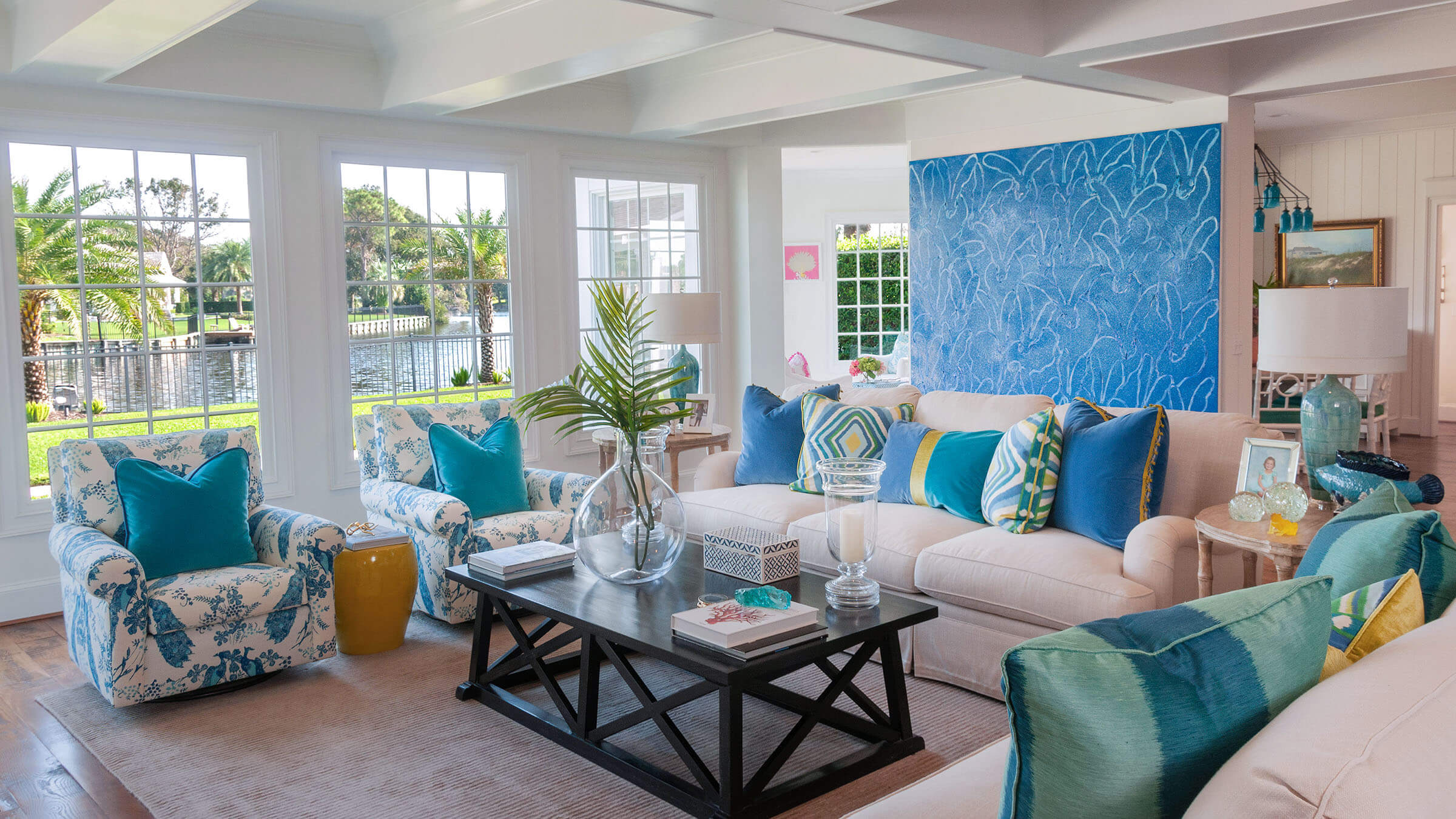 Luxury coastal living room interior designed by Laura West of Mineral City, featuring bright blue accents and waterfront views in Ponte Vedra Beach, FL.